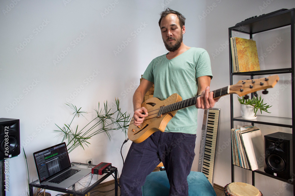 Obraz premium Musician playing electric guitar in home music studio.