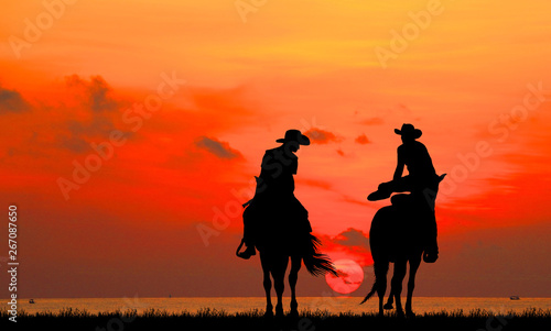 silhouette Cowboy riding a horse on sunrise