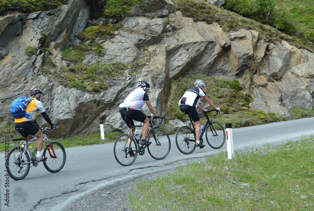 Fototapeta premium Cyclists ride on a mountain road in the Alps.