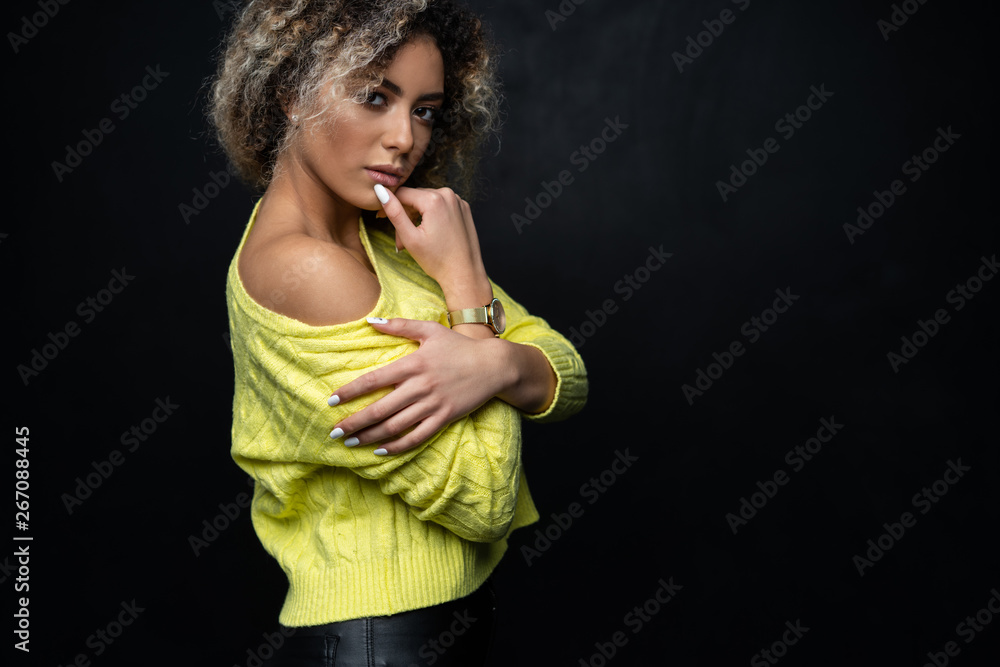 Portrait of a beautiful black female fashion model with curly hair over black background. Portrait of a beautiful black female fashion model with curly hair over black background.