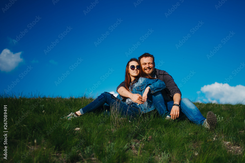 Man and woman sitting on the green grass together in the summer Man and woman sitting on the green grass together in the summer