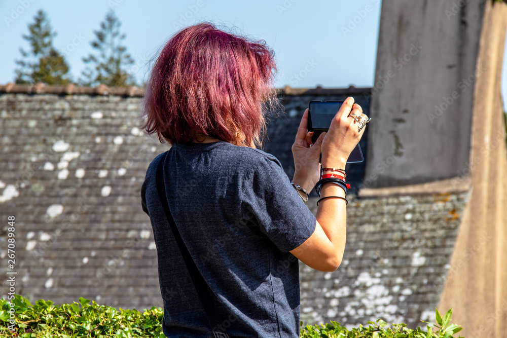 Jeune femme faisant des photos avec un téléphone portable Jeune femme faisant des photos avec un téléphone portable