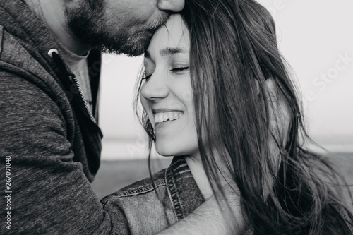 Black and white photography portrait girl closeup eyes closed, a man hugs a girl, the girl smiles