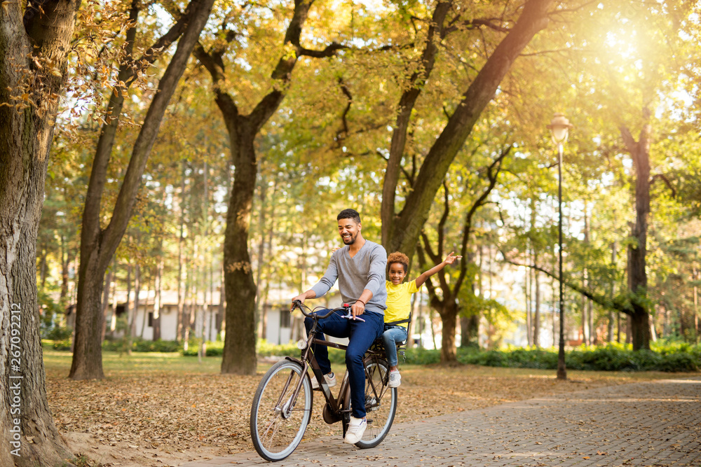 Father and daughter enjoying bicycle ride in nature. Happy family time.