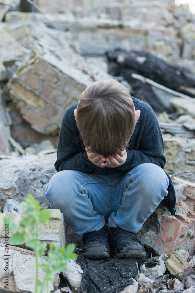 Little boy near the destroyed house. Child trouble, loneliness concept. Little boy near the destroyed house. Child trouble, loneliness concept.