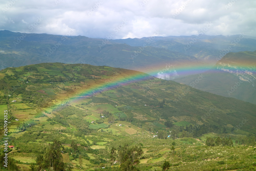 Beautiful rainbow over the lower mountaintop village view from Kuelap ancient citadel in Amazonas region, northern Peru
