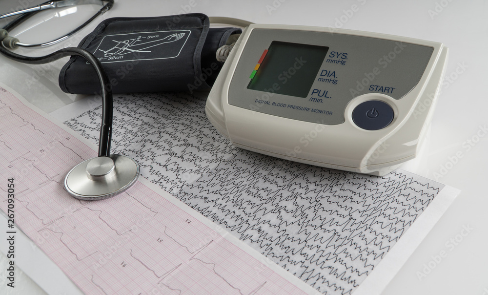 modern electric tonometer and a stethoscope on a cardiogram chart. household blood pressure monitor modern electric tonometer and a stethoscope on a cardiogram chart. household blood pressure monitor