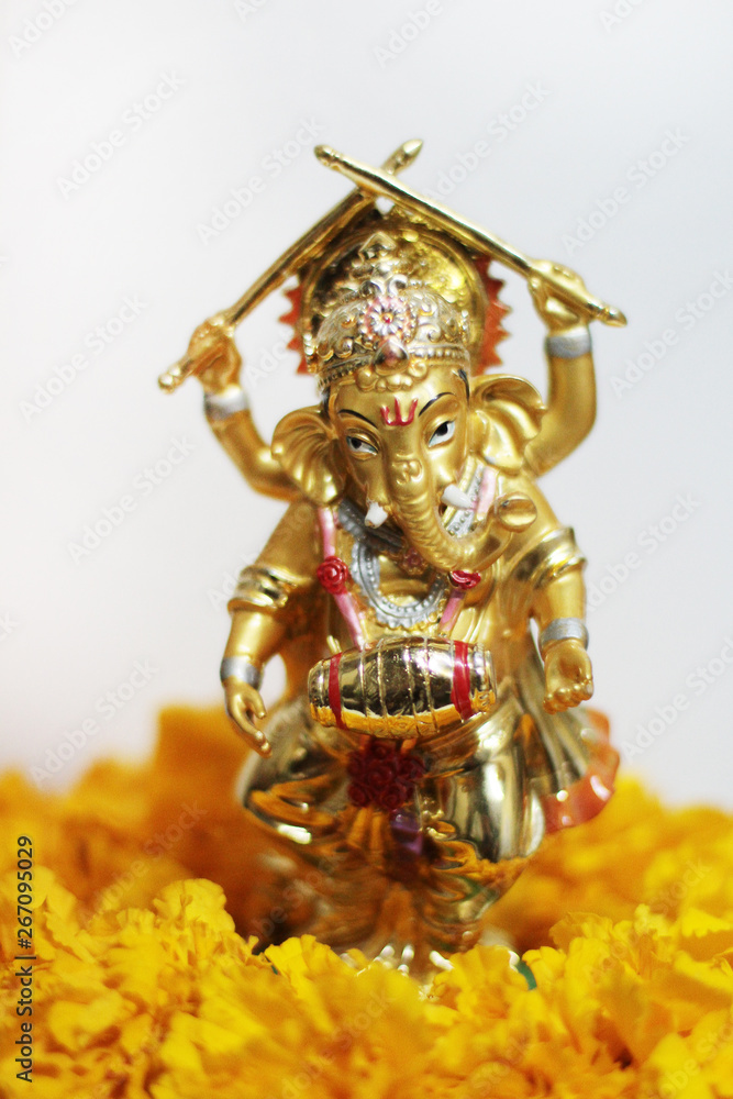 Gold Ganesha god is the Lord of Success God of Hinduism on Marigold flowers Isolated on white background.