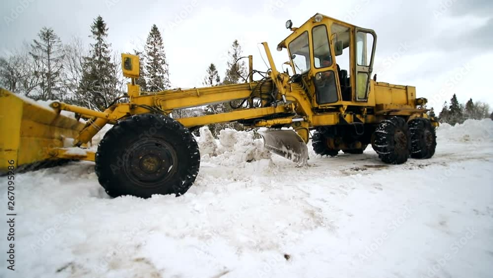A tractor clears snow from the land for car Cleaning snow from the great marker technique A tractor clears snow from the land for car Cleaning snow from the great marker technique