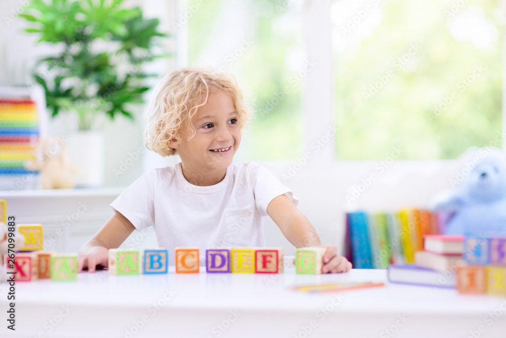 Child learning letters. Kid with wooden abc blocks Child learning letters. Kid with wooden abc blocks