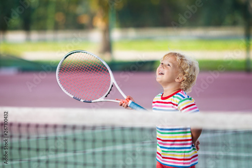 Child playing tennis on outdoor court
