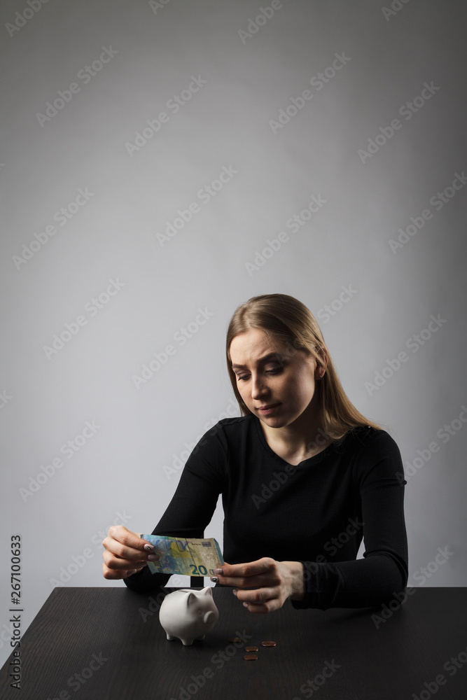 Young woman in black and piggy bank Young woman in black and piggy bank