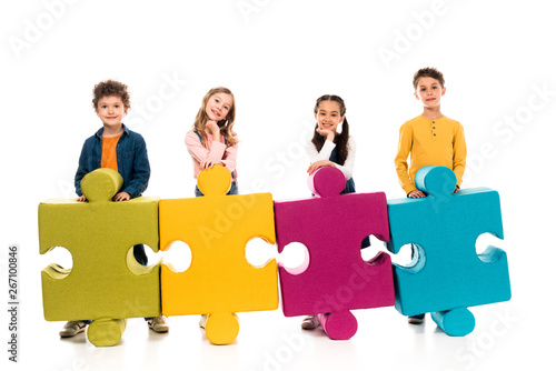 full length view of kids with colorful jigsaw puzzles on white