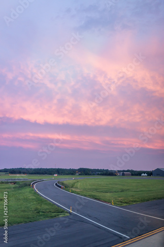 Dulles, USA International Airport, IAD, runway with colorful dramatic pink red vibrant sunset in Virginia airfield