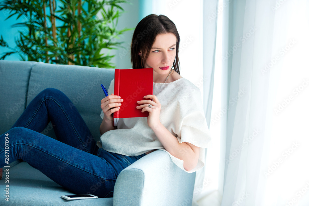girl with a red note book at home girl with a red note book at home