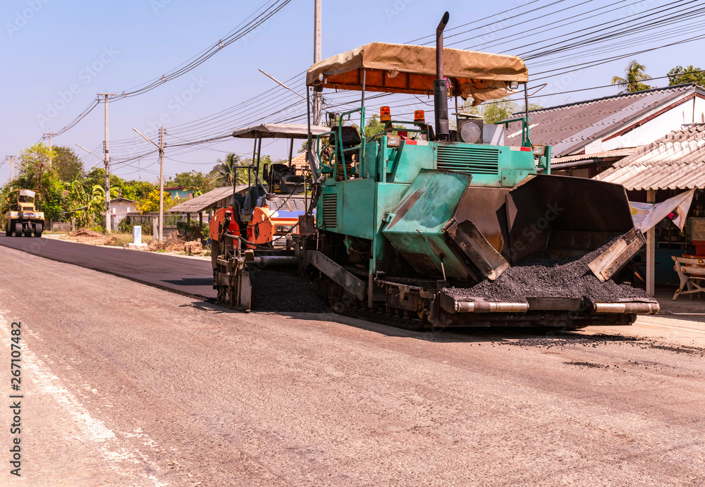 Fototapeta premium Close view on the workers and the asphalting machines, Workers making asphalt at road construction