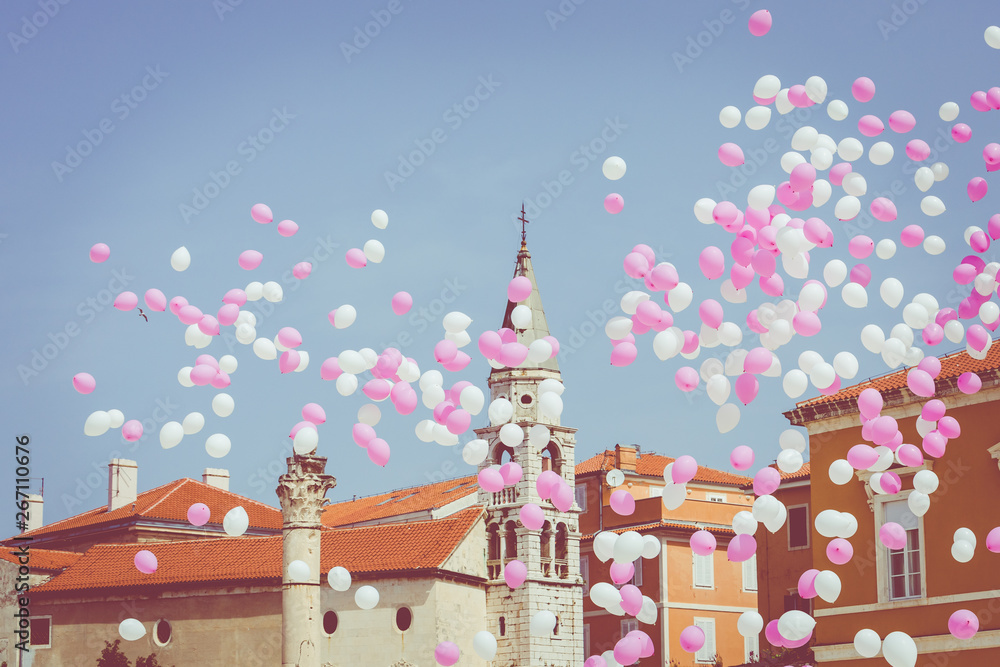 Pink and white balloons on a blue sky at historic center of the Croatian town of Zadar at the Mediterranean Sea, Europe.
