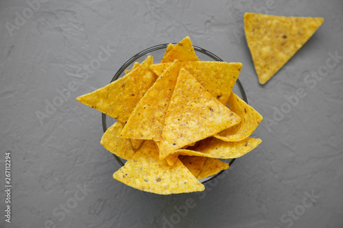 Tortilla chips in glass bowl over concrete surface, top view. Mexican food. From above, overhead.