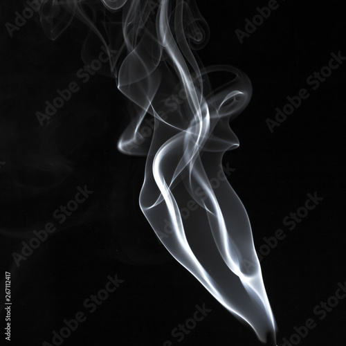 Abstract white smoke swirls pattern over the black background