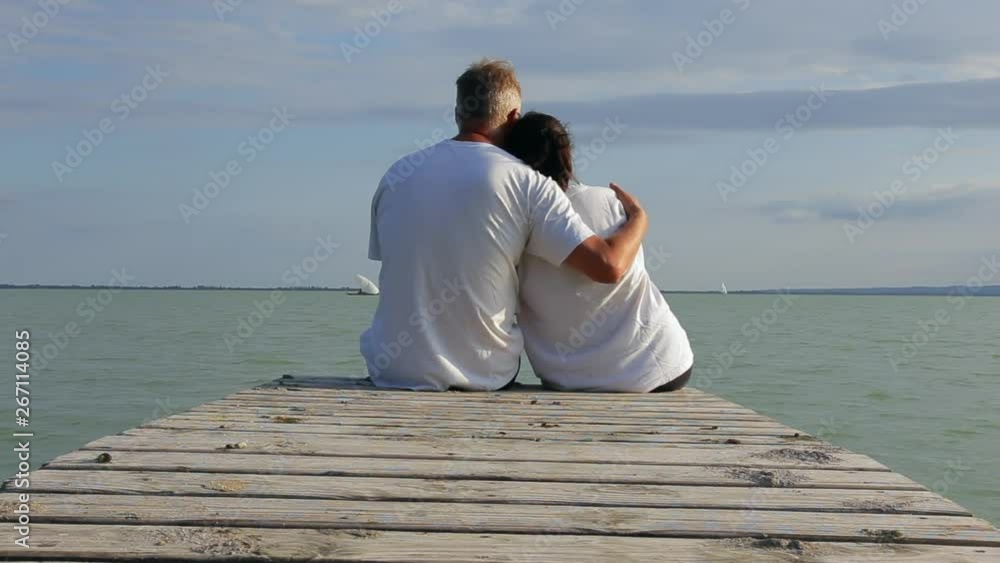 Middle age couple on the pier in a lake Balaton of Hungary at summertime Middle age couple on the pier in a lake Balaton of Hungary at summertime