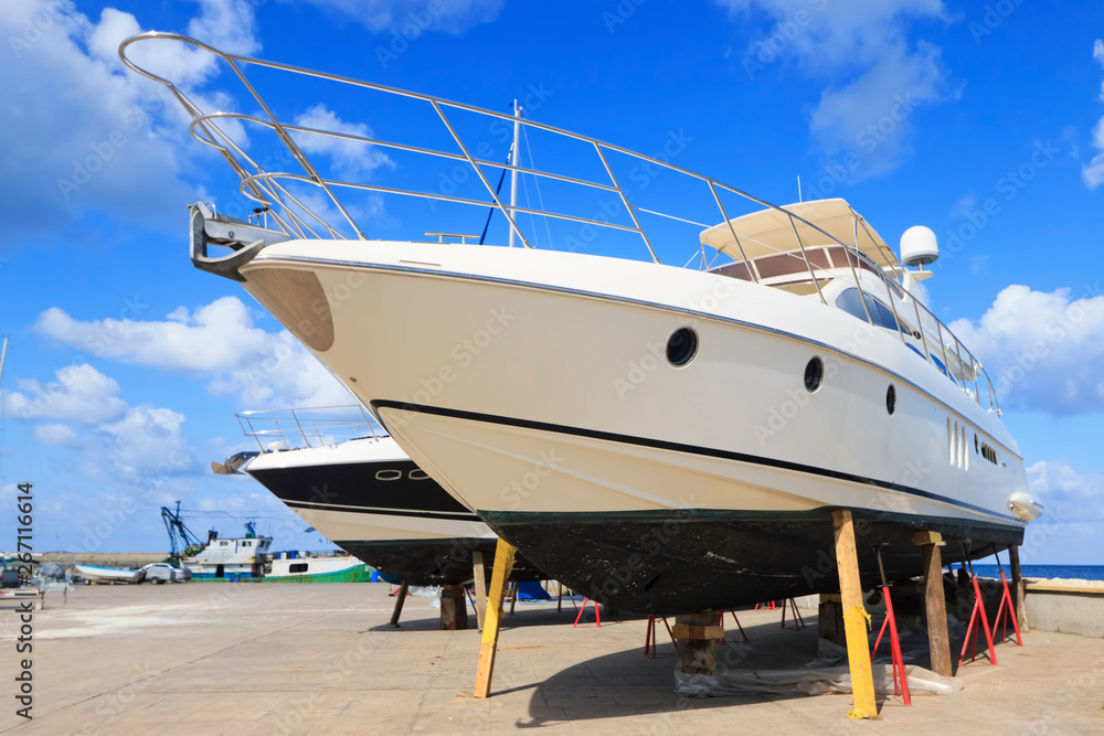 Luxury motor yacht beached on a dry dock for painting and repair