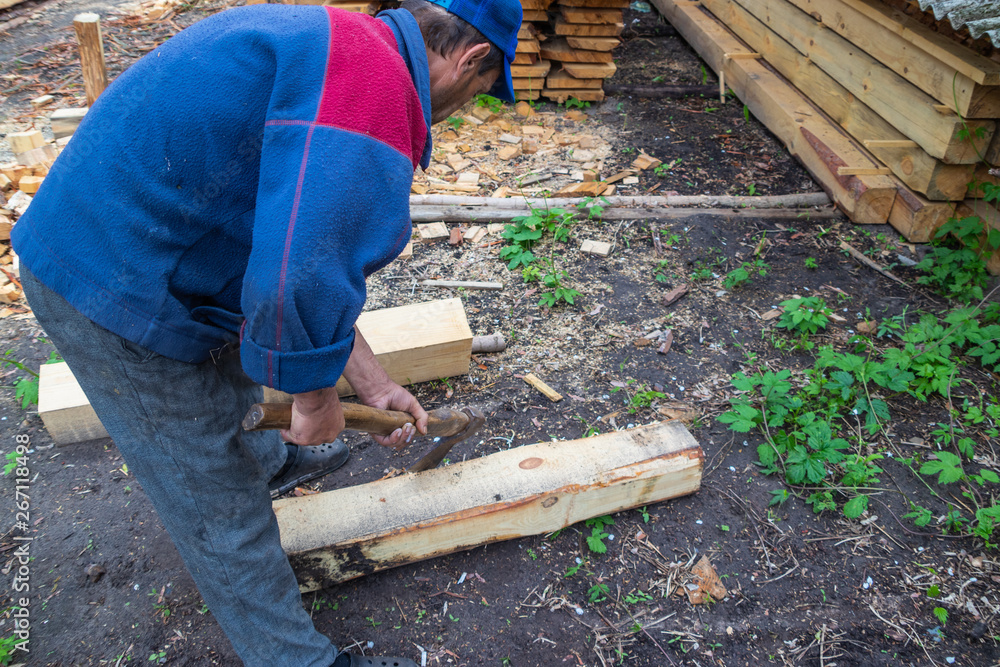 Master carpenter professionally working with an ax Master carpenter professionally working with an ax