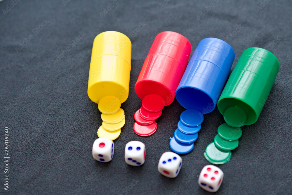 four beakers, each one in one color (yellow, red, blue, green) with four pawns and one dice each one. four beakers, each one in one color (yellow, red, blue, green) with four pawns and one dice each one.
