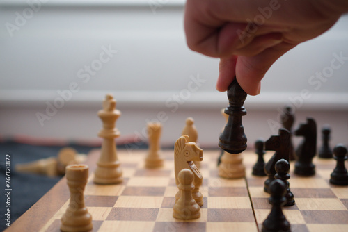 Man playing chess, moving a black bishop