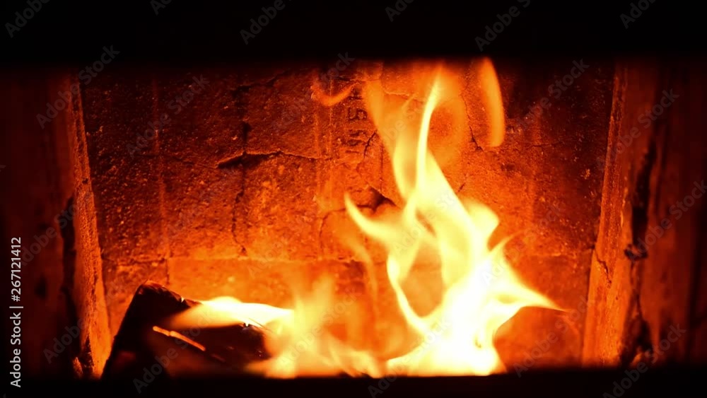 Burning woods in the hot bakery fire with orange and yellow flames with deep stove doors frame visible close up selective focus slow motion Burning woods in the hot bakery fire with orange and yellow flames with deep stove doors frame visible close up selective focus slow motion