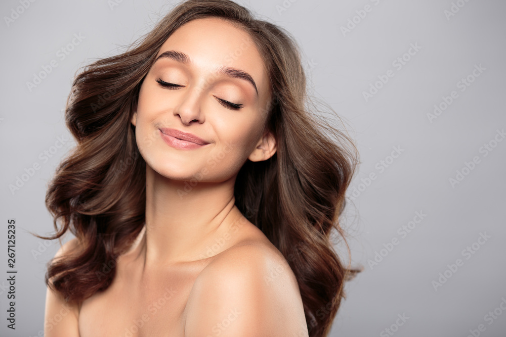 Brunette girl with healthy curly hair and natural make up . Beautiful model woman with wavy hairstyle .Care and beauty Brunette girl with healthy curly hair and natural make up . Beautiful model woman with wavy hairstyle .Care and beauty