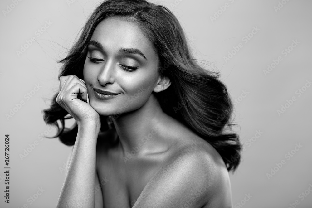 Fototapeta premium Brunette girl with healthy curly hair and natural make up . Beautiful model woman with wavy hairstyle .Care and beauty