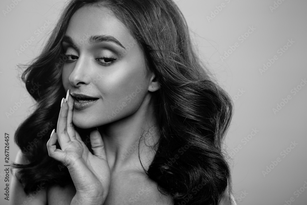 Brunette girl with healthy curly hair and natural make up . Beautiful model woman with wavy hairstyle .Care and beauty Brunette girl with healthy curly hair and natural make up . Beautiful model woman with wavy hairstyle .Care and beauty