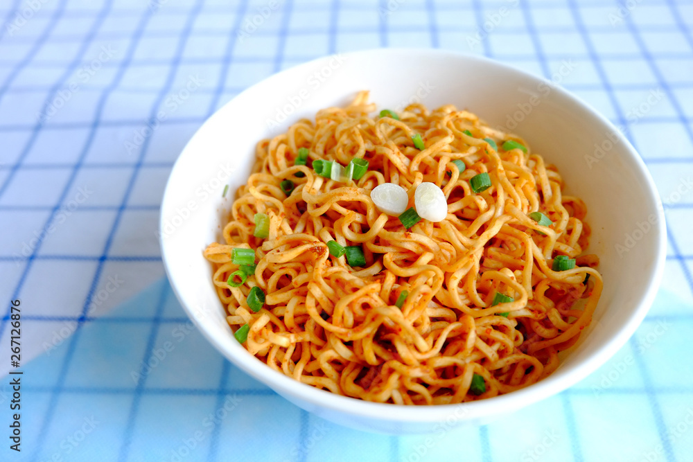 Dried instant noodle in white ceramic bowl on tablecloth Dried instant noodle in white ceramic bowl on tablecloth