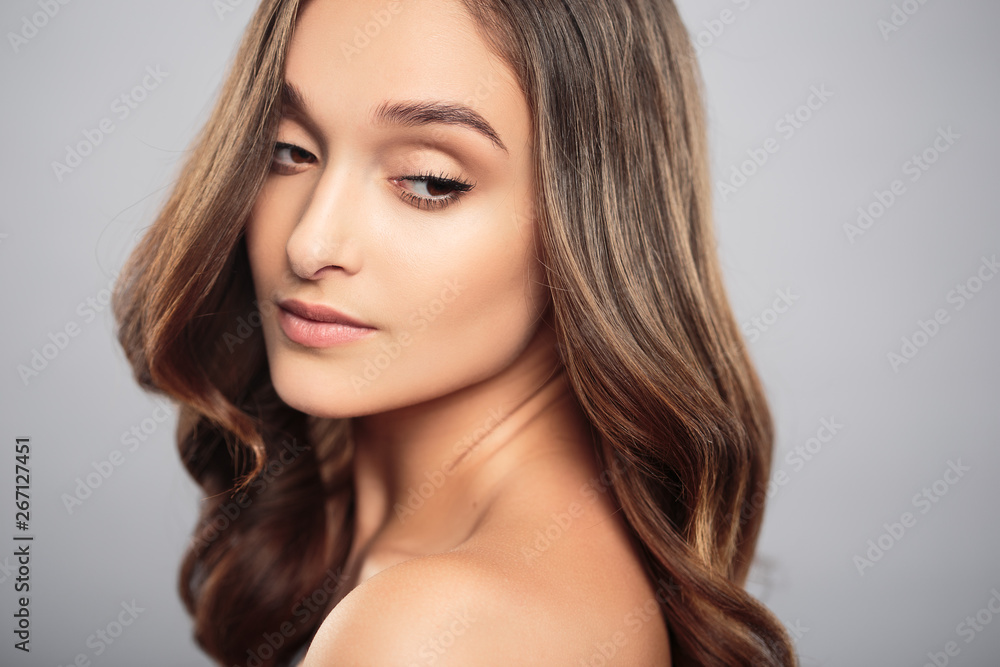 Brunette girl with healthy curly hair and natural make up . Beautiful model woman with wavy hairstyle .Care and beauty Brunette girl with healthy curly hair and natural make up . Beautiful model woman with wavy hairstyle .Care and beauty