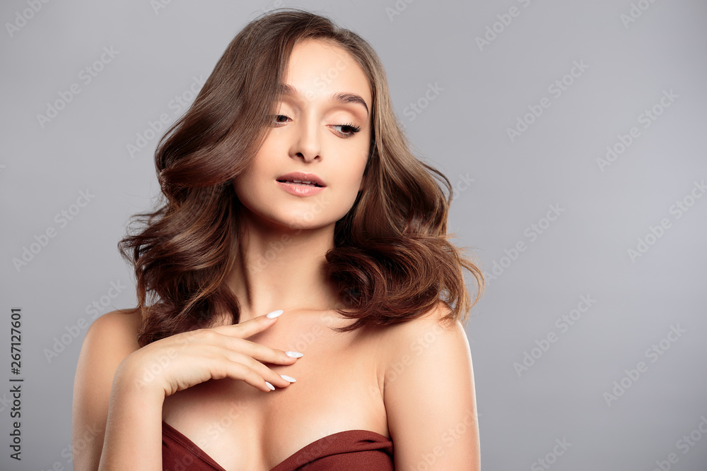 Brunette girl with healthy curly hair and natural make up . Beautiful model woman with wavy hairstyle .Care and beauty Brunette girl with healthy curly hair and natural make up . Beautiful model woman with wavy hairstyle .Care and beauty