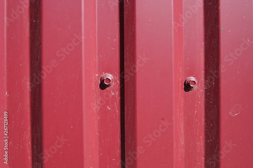 Background striped red metal profile. Texture of painted red metal surface