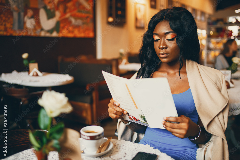 Elegant black woman sitting in a cafe. Businesswoman drinking a coffee Elegant black woman sitting in a cafe. Businesswoman drinking a coffee