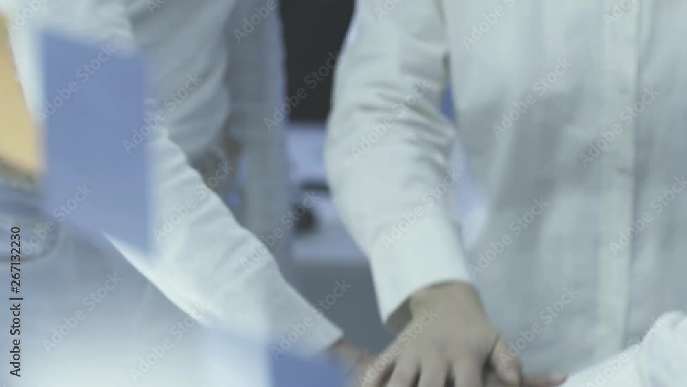 Cheerful business team stacking hands Cheerful business team stacking hands