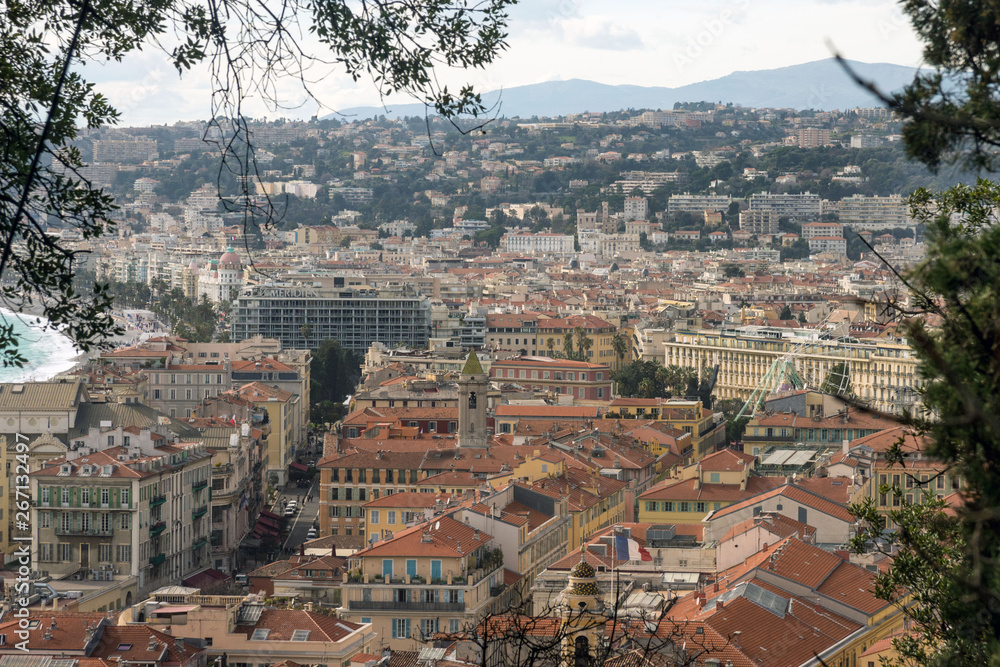 Fototapeta premium Nice, France, March 2019. View of the French city of Nice from the observation deck of the fortress. Mountains, sky and rooftops on a sunny day.