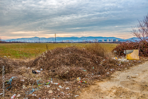 Scattered garbage at a pull-over-area, the town of Stara Zagora, Zora District, Bulgaria in the background photo