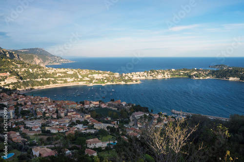  Private yachts and boats are parked near the coast. Beautiful mountains, the lighthouse and the turquoise sea - a great place to relax. Sunset in Nice, France.