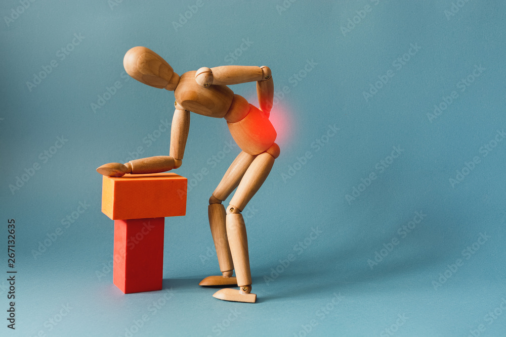 Concept of back pain. A wooden figure depicts a pain in the back.