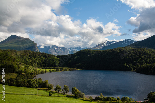 View over lake and mountains with cloudy sky in Norway
