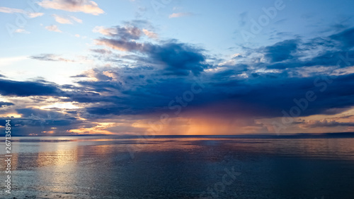 Sunset on Lake Baikal. Evening, rain, clouds, sun. Dramatic sky. Atmospheric landscape. The shore of Lake Baikal. Russia. © Vero