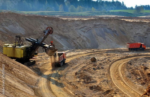 Quarry excavator loading sand or into dump truck at opencast. Excavation of mineral resources, the work of special mining equipment - Image