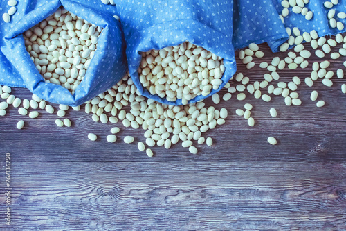not cooked white beans on the table. the beans in cloth bags. harvest of white beans. background with beans.
