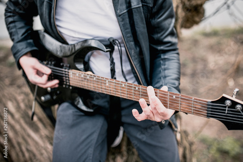 Close-up of playing black electric guitar - rock and roll