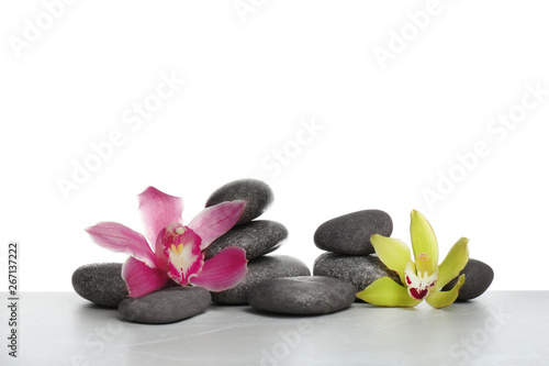 Beautiful orchid flowers with different spa stones on white background