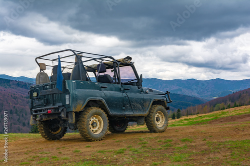 Extreme tourist trip to the top of the mountain on the dirt and stones on a special off-road Jeep to see the beauty of the mountains and forests on the horizon on top of the world photo