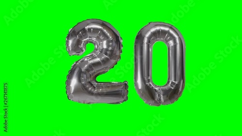 Number 20 twenty years birthday anniversary silver balloon floating on green screen